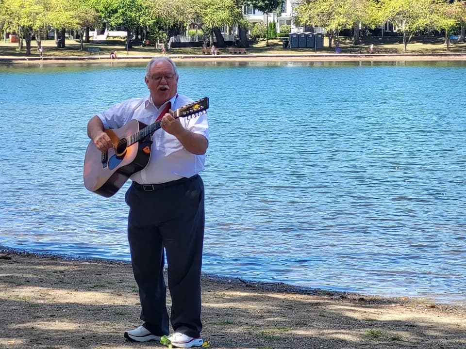 Leading a song with a guitar on the shore of Lake Anna